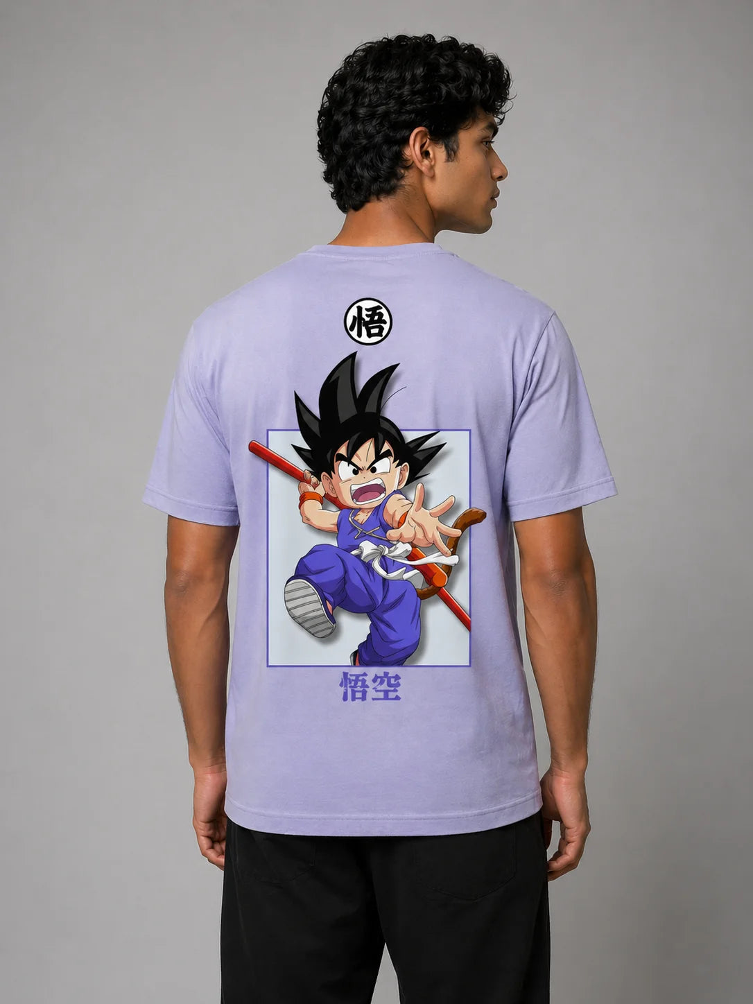 Back view of a male model wearing a lavender classic-fit cotton T-shirt against a light gray studio background, featuring a centered anime graphic of a young warrior character in motion with Japanese text below and a small circular symbol near the upper back.