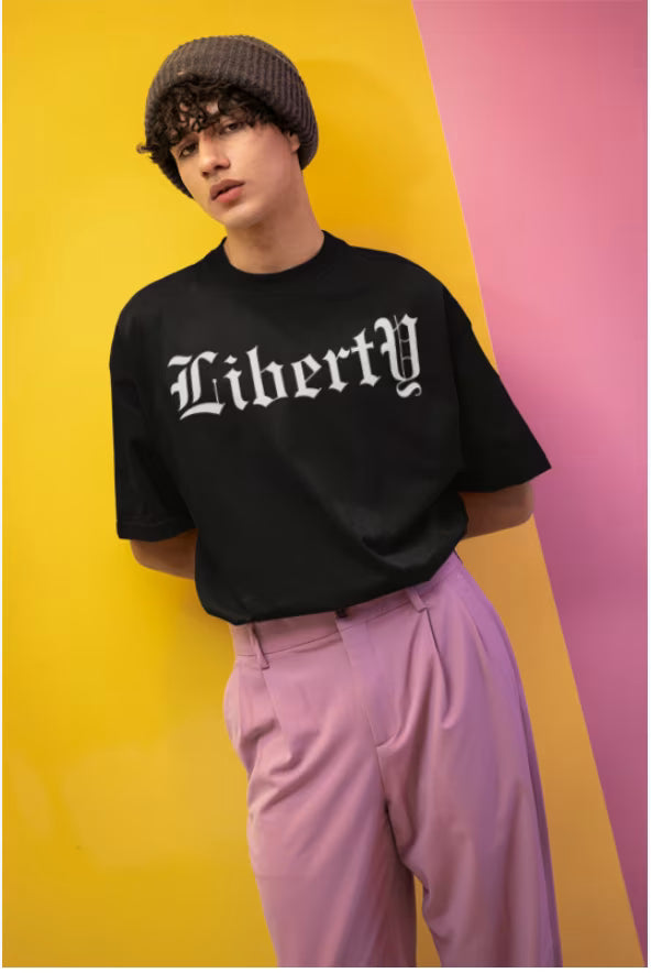 Male model wearing the Noir - Hedes Liberty Unisex Terry Oversized Tee (UT27) in a high-fashion editorial streetwear setting.