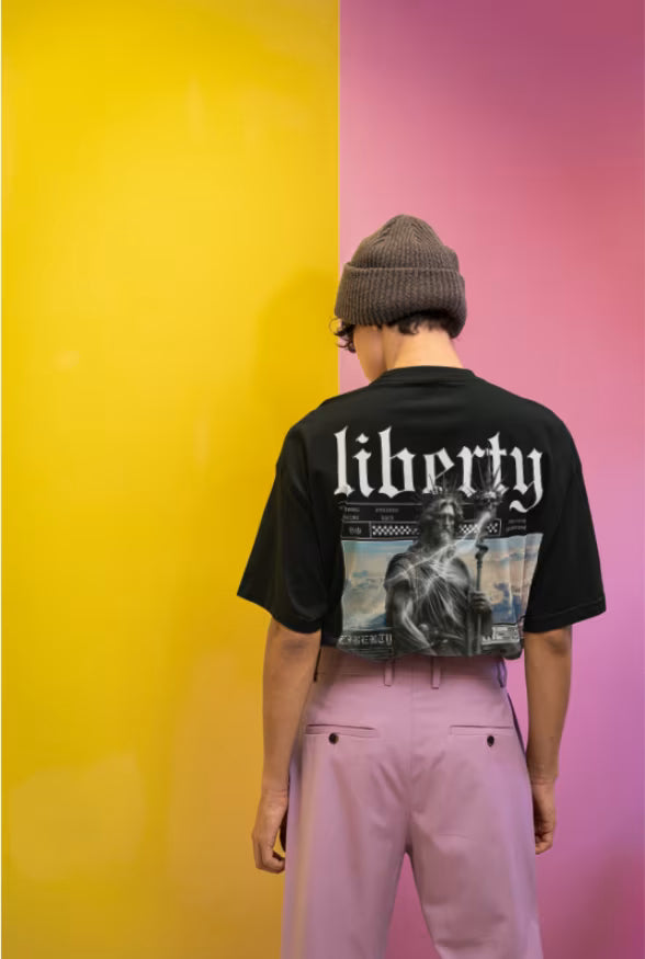 Male model wearing the Noir - Hedes Liberty Unisex Terry Oversized Tee (UT27) in a high-fashion editorial streetwear setting.